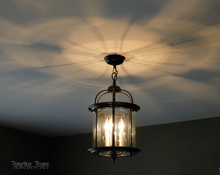 Spray painting a lantern light fixture from the Restore